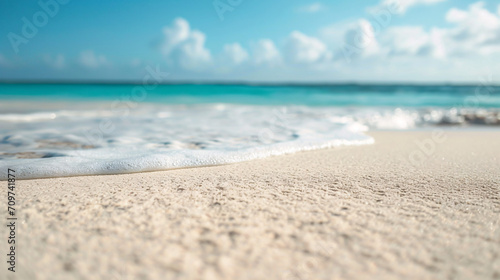 White sand at a tropical beach close-up, ocean in the background © Dennis