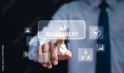 Assessment concept. Businessman touching assessment icons on  virtual screen for assessment analysis, evaluation measure and business analytics technology.
