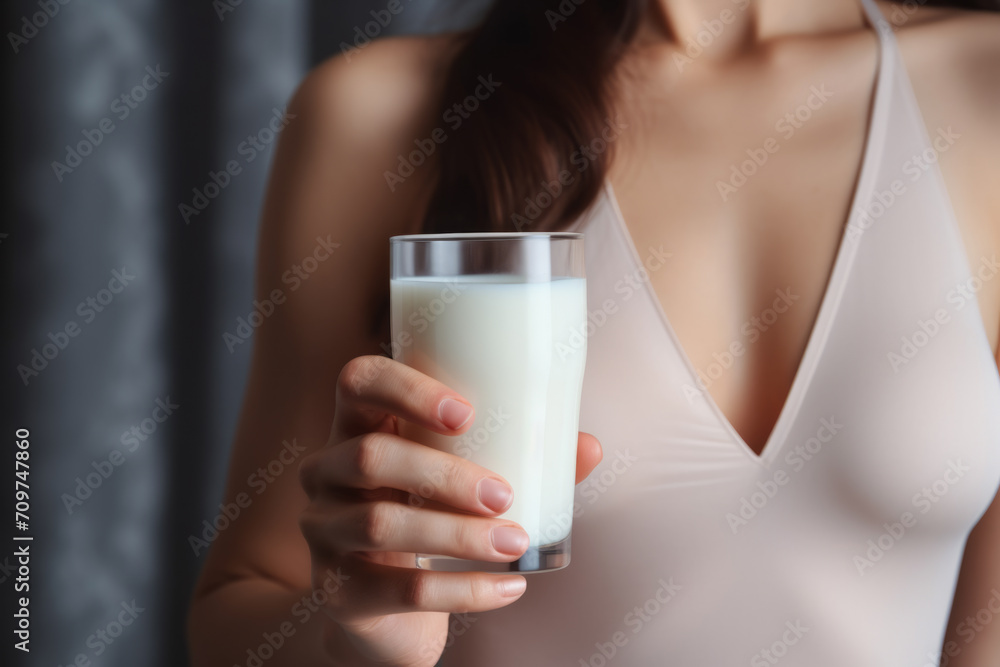Young woman drinks calciumrich milk for strong bones. Young woman drinks calciumrich milk for strong bones.