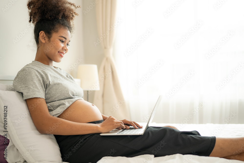 Multiracial expectant mother resting in peaceful bedroom in daytime. Young adult pregnant woman care for her beginning mom waiting for childbirth. Maternity, motherhood, pregnancy photography concept. Multiracial expectant mother resting in peaceful bedroom in daytime. Young adult pregnant woman care for her beginning mom waiting for childbirth. Maternity, motherhood, pregnancy photography concept.