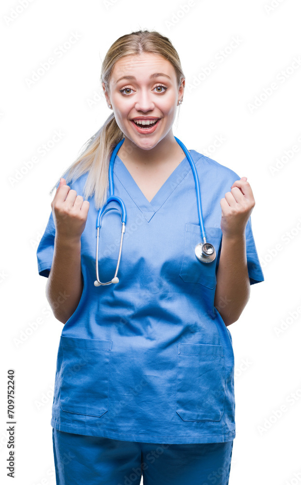 Young blonde surgeon doctor woman over isolated background celebrating surprised and amazed for success with arms raised and open eyes. Winner concept. Young blonde surgeon doctor woman over isolated background celebrating surprised and amazed for success with arms raised and open eyes. Winner concept.