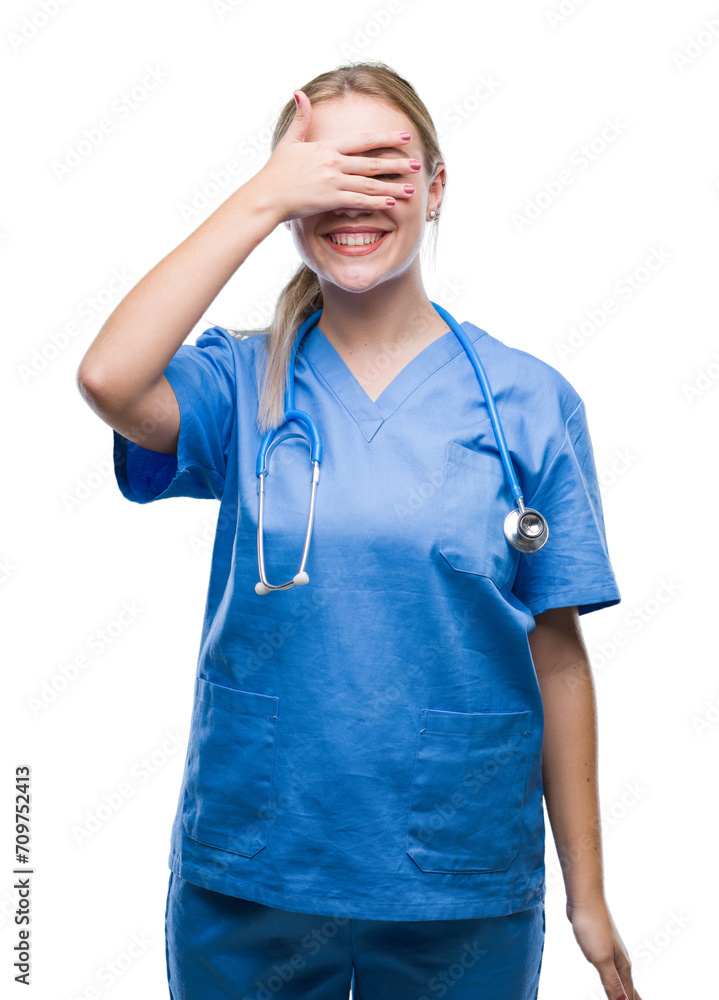 Young blonde surgeon doctor woman over isolated background smiling and laughing with hand on face covering eyes for surprise. Blind concept. Young blonde surgeon doctor woman over isolated background smiling and laughing with hand on face covering eyes for surprise. Blind concept.