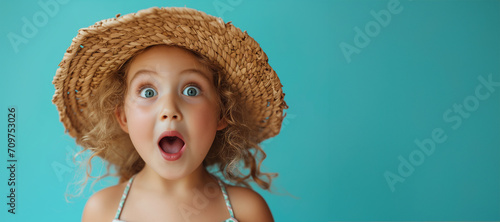 Beautiful girl wearing straw hat and sunglasses posing with open mouth, recives shocking. Shocked astonished surprised kid girl looking at camera with open mouth and big eyes photo