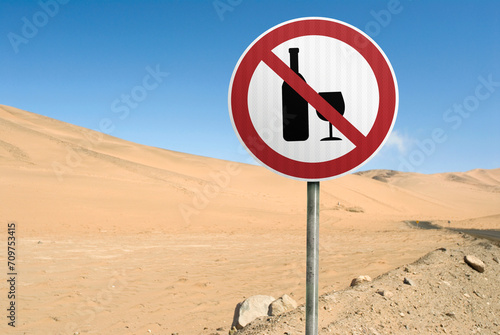 Red circular prohibition sign "No drinking". Alone sign in the desert with blue sky background. Copy space for text, message and ironic, funny phrases.