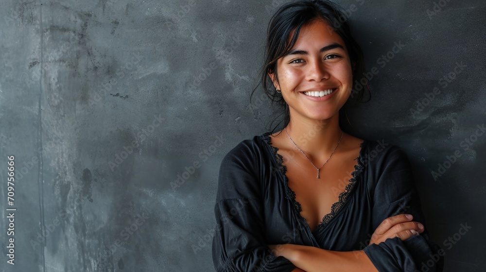 Fototapeta premium Arms folded, lovely girl against a grey wall.