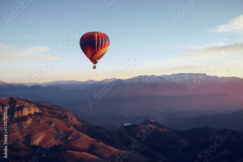 Balão de ar quente voando no céu em uma paisagem de montanhas ao entardecer
