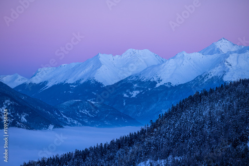 sommets d'une chaîne de montagne enneigée au crépuscule avec un beau ciel rose