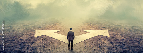 person at a crossroads with two large white arrows pointing in opposite directions on a cracked surface, set against a foggy, ambiguous background, symbolizing a decision point or dilemma photo
