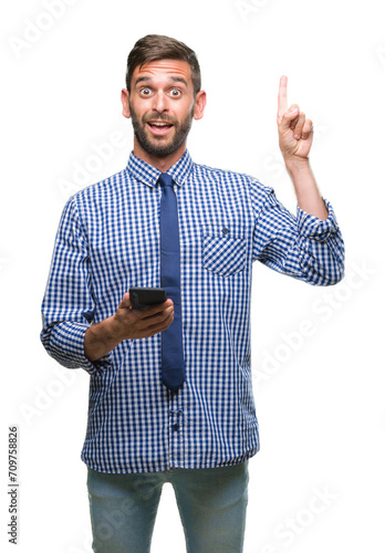 Young hadsome man texting sending message using smartphone over isolated background surprised with an idea or question pointing finger with happy face, number one photo