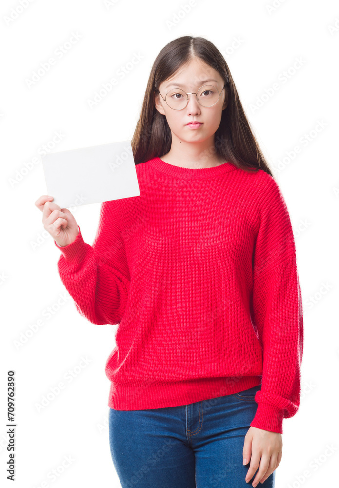 Young Chinese woman over isolated background holding blank card with a confident expression on smart face thinking serious Young Chinese woman over isolated background holding blank card with a confident expression on smart face thinking serious