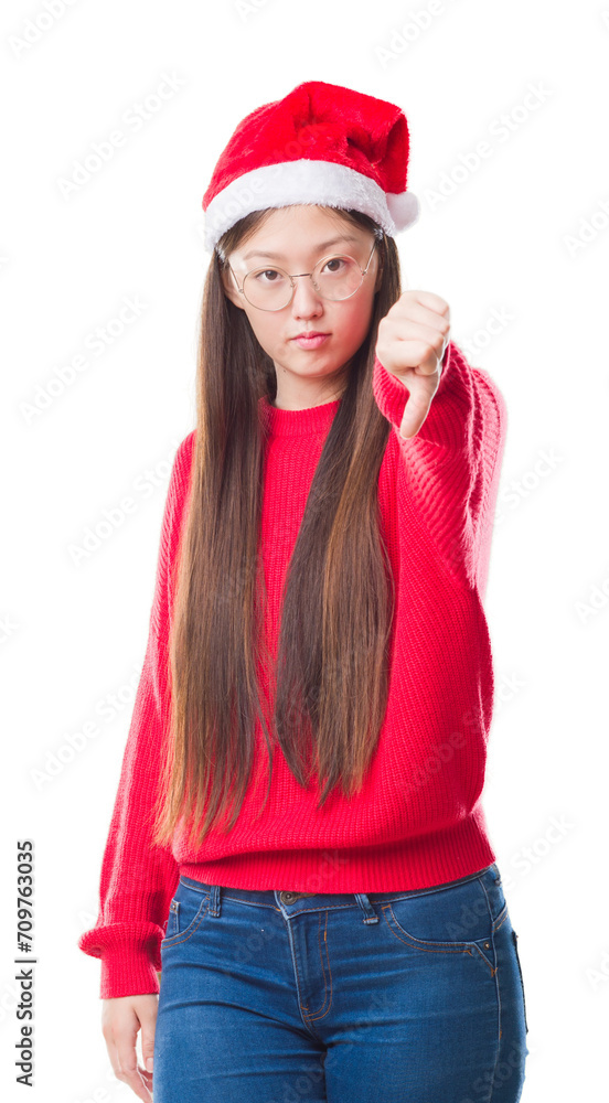 Young Chinese woman over isolated background wearing christmas hat looking unhappy and angry showing rejection and negative with thumbs down gesture. Bad expression. Young Chinese woman over isolated background wearing christmas hat looking unhappy and angry showing rejection and negative with thumbs down gesture. Bad expression.