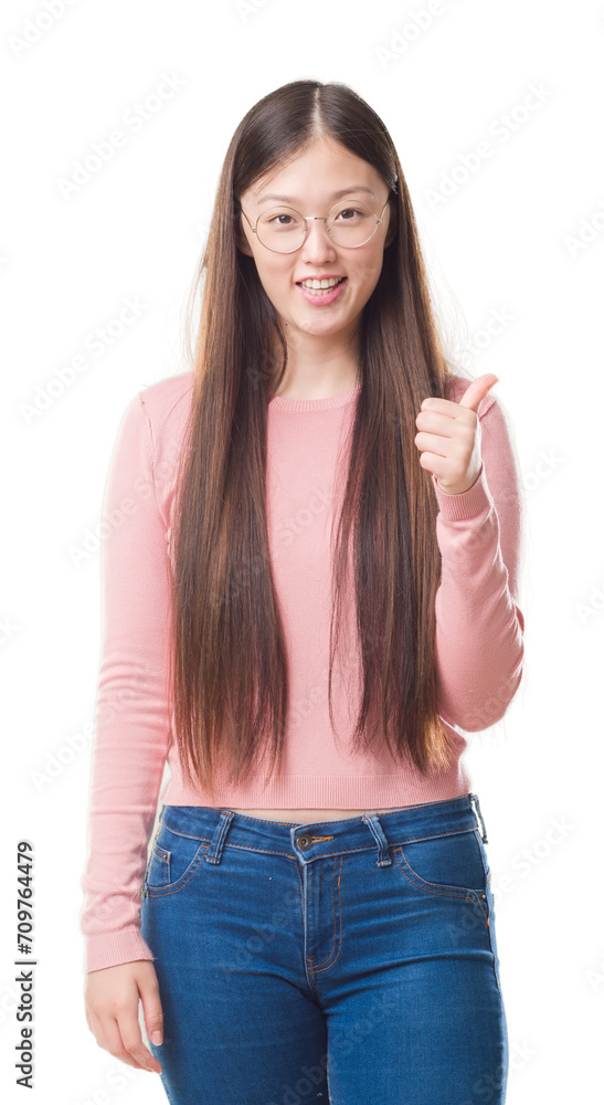 Young Chinese woman over isolated background wearing glasses doing happy thumbs up gesture with hand. Approving expression looking at the camera with showing success. Young Chinese woman over isolated background wearing glasses doing happy thumbs up gesture with hand. Approving expression looking at the camera with showing success.