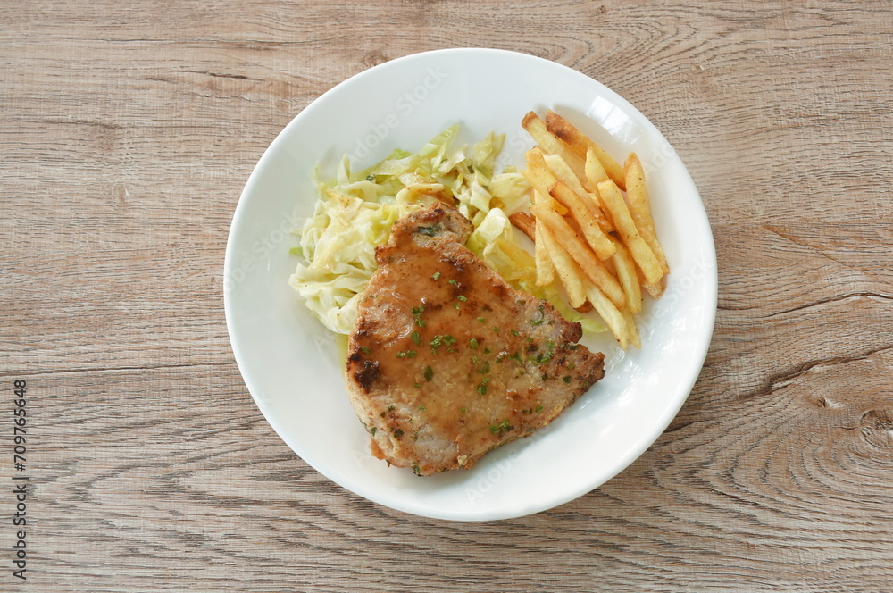 grilled  pork steak with French fries and salad dressing mayonnaise in plate 