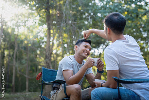 Male gay couple asian traveling with tent camping outdoor and various adventure lifestyle hiking active summer vacation. drinking coffee and talking together © Natee Meepian