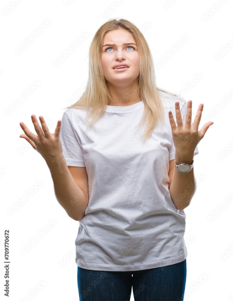 Fototapeta premium Young caucasian woman over isolated background crazy and mad shouting and yelling with aggressive expression and arms raised. Frustration concept.