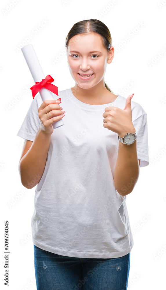 Young caucasian woman holding degree over isolated background happy with big smile doing ok sign, thumb up with fingers, excellent sign Young caucasian woman holding degree over isolated background happy with big smile doing ok sign, thumb up with fingers, excellent sign