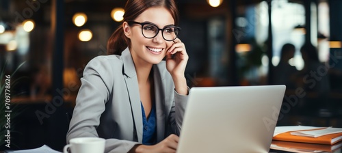 Happy young woman working from home, using smartphone and laptop for remote work and hybrid learning