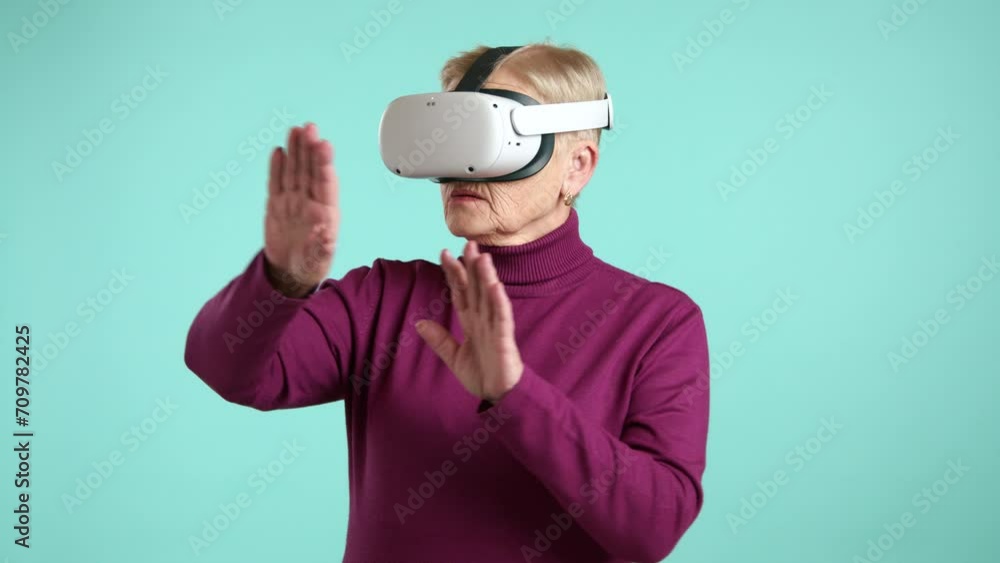 Elderly lady having new experience of using VR goggles, impressed by the touchy-feely world of the metaverse. Advanced female pensioner using future gadget. High quality 4k footage Elderly lady having new experience of using VR goggles, impressed by the touchy-feely world of the metaverse. Advanced female pensioner using future gadget. High quality 4k footage