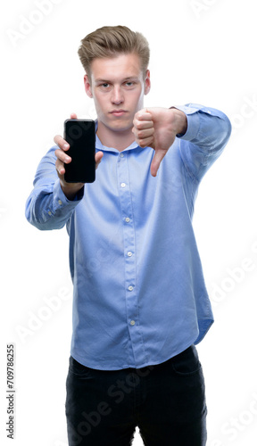 Young handsome blond man using smartphone with angry face, negative sign showing dislike with thumbs down, rejection concept