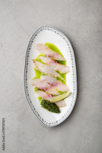 Sea bass carpaccio with lime and green butter dressing