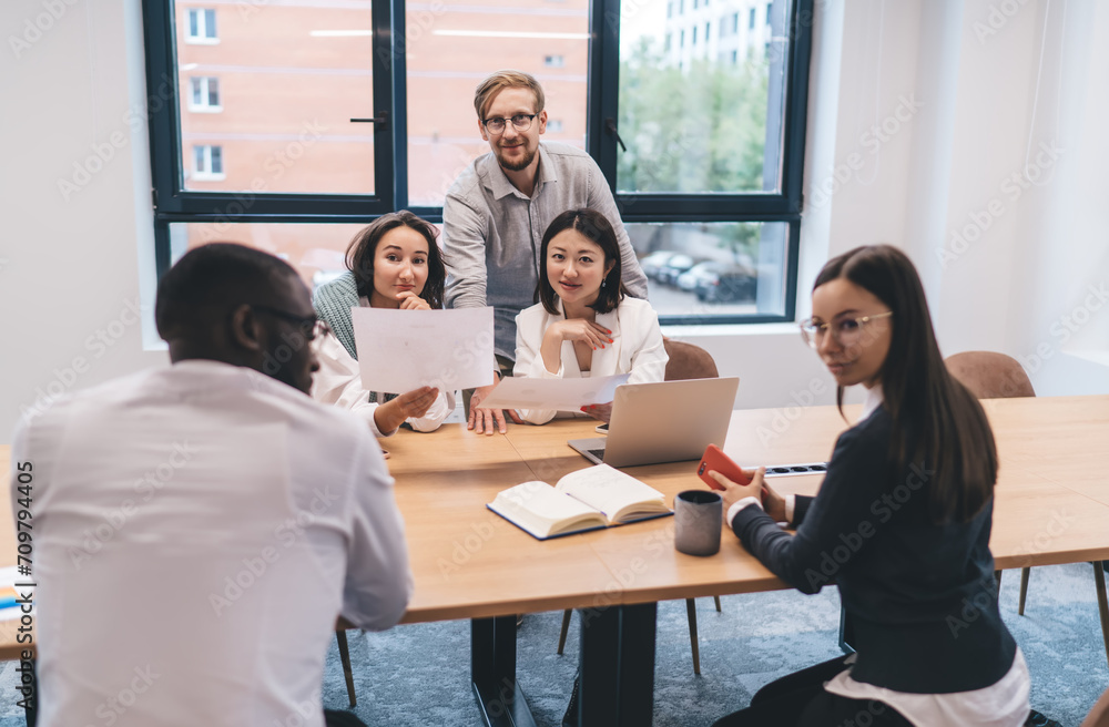 Group of diverse colleagues discussing together work project in office