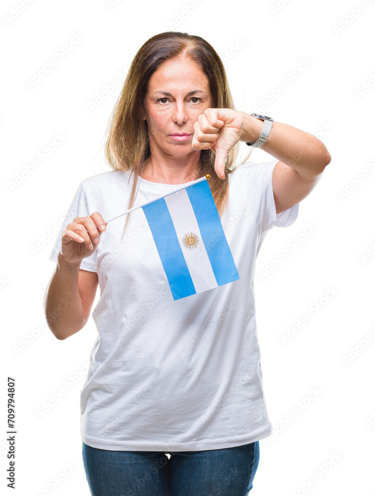 Middle age hispanic woman holding flag of Argentina over isolated background with angry face, negative sign showing dislike with thumbs down, rejection concept Middle age hispanic woman holding flag of Argentina over isolated background with angry face, negative sign showing dislike with thumbs down, rejection concept