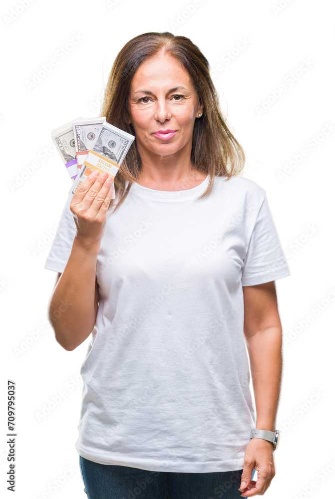 Middle age hispanic woman holding bunch of dollars over isolated background with a confident expression on smart face thinking serious Middle age hispanic woman holding bunch of dollars over isolated background with a confident expression on smart face thinking serious