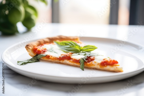 margherita pizza slice on a white plate with basil garnish