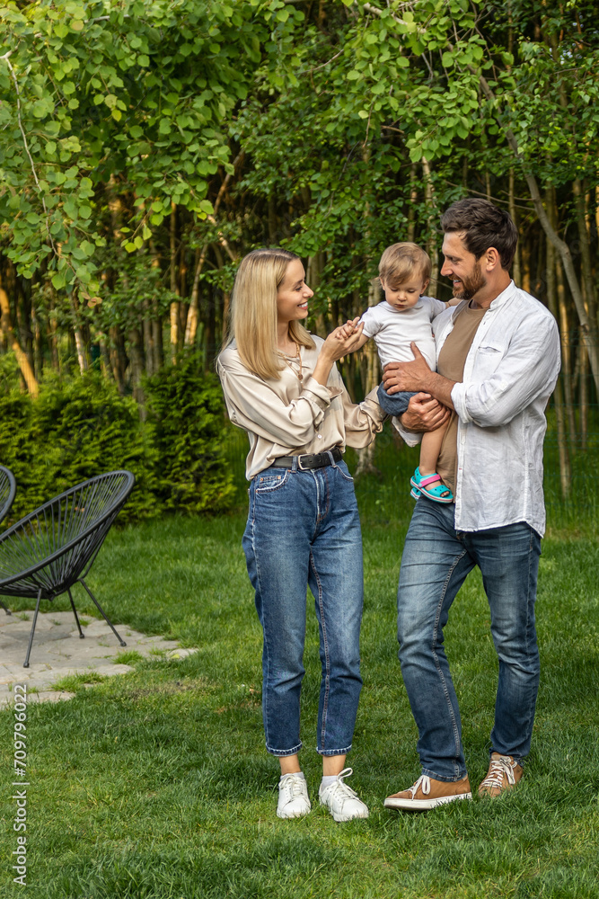Fototapeta premium Cute young couple with their baby looking happy