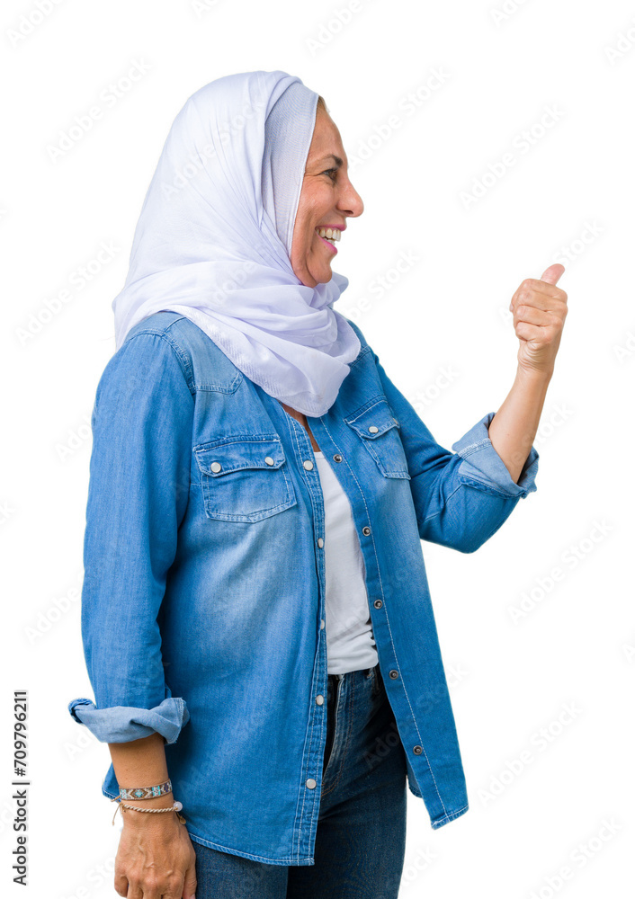 Middle age eastern arab woman wearing arabian hijab over isolated background Looking proud, smiling doing thumbs up gesture to the side Middle age eastern arab woman wearing arabian hijab over isolated background Looking proud, smiling doing thumbs up gesture to the side