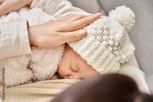 cropped view of loving mother holding her newborn child and breastfeeding him, modern parenting