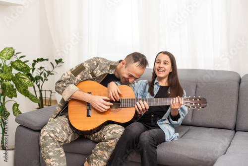 a veteran and his daughter play the guitar