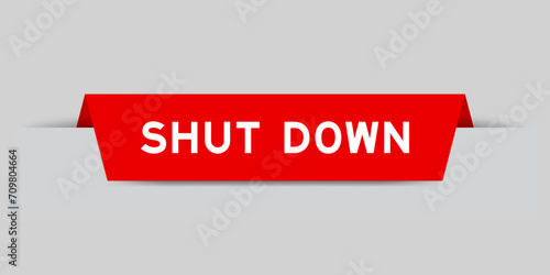 Red color inserted label with word shut down on gray background
