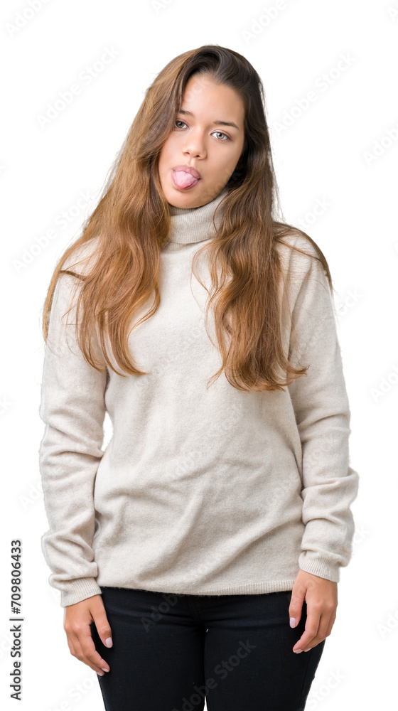 Young beautiful brunette woman wearing turtleneck sweater over isolated background sticking tongue out happy with funny expression. Emotion concept. Young beautiful brunette woman wearing turtleneck sweater over isolated background sticking tongue out happy with funny expression. Emotion concept.