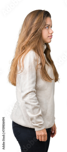 Young beautiful brunette woman wearing turtleneck sweater over isolated background looking to side, relax profile pose with natural face with confident smile.