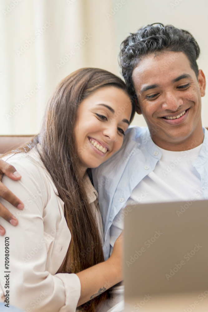 Young couple moving to a new home relaxing sitting on the sofa using computer laptop, smiling happy for moving to new apartment Young couple moving to a new home relaxing sitting on the sofa using computer laptop, smiling happy for moving to new apartment