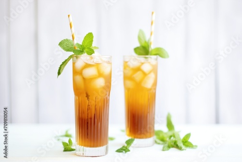 iced tea in tall glasses with mint leaves and straws