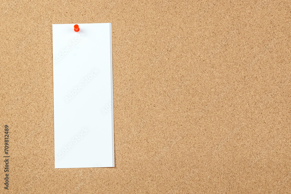 Blank sheet of paper pinned to a cork board. Copy space. Blank sheet of paper pinned to a cork board. Copy space.