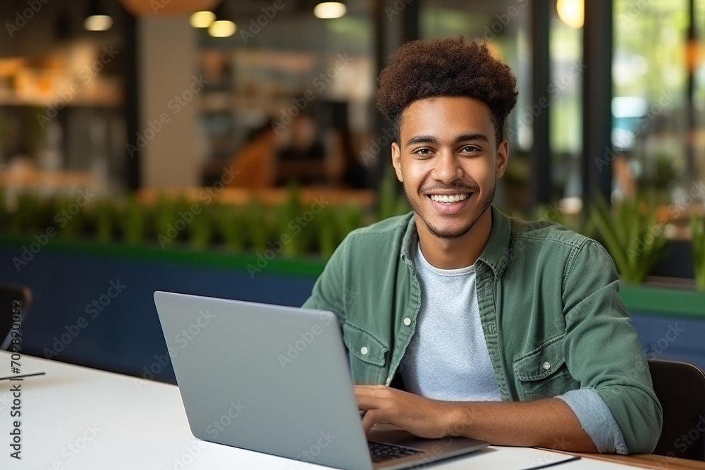 Happy African Black guy student using laptop computer in university library Happy African Black guy student using laptop computer in university library