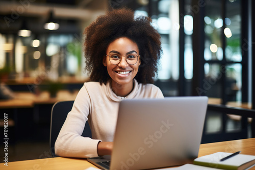 Happy African Black girl student using laptop computer in university library