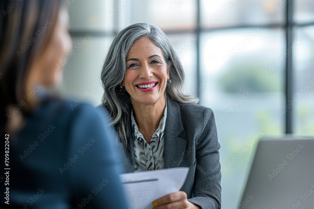 Confident Mature Businesswoman in Corporate Setting Engaging in Professional Consultation, Holding CV with a Pleasant Demeanor, Legal Advisor at Work, Employment Expert Discussing Career Opportunities Confident Mature Businesswoman in Corporate Setting Engaging in Professional Consultation, Holding CV with a Pleasant Demeanor, Legal Advisor at Work, Employment Expert Discussing Career Opportunities