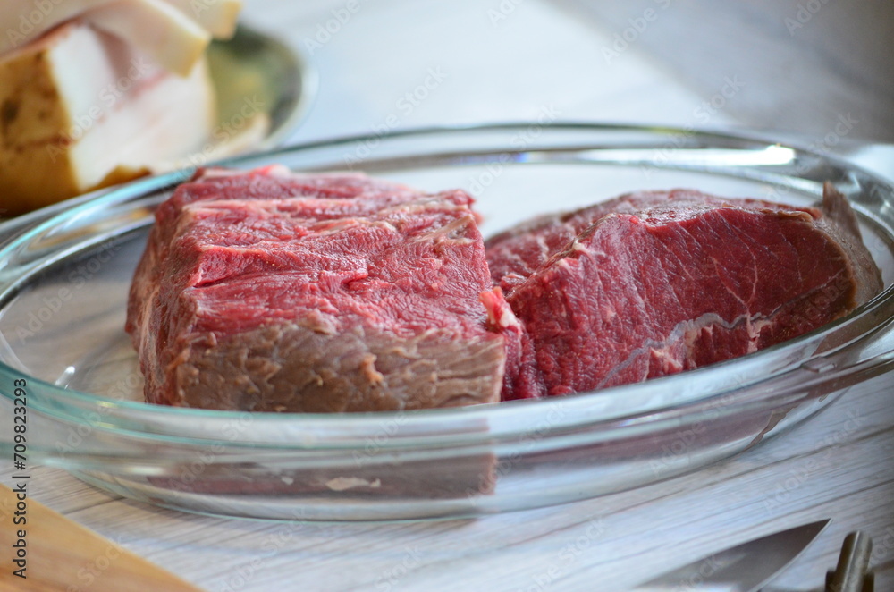 raw meat on a white background in a glass container, close-up raw meat on a white background in a glass container, close-up