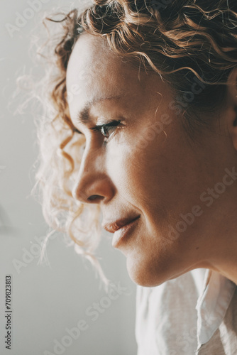 Side portrait of pensitive woman. Remembering memories and unhealthy mental disease. Serene female looking in front. People with thoughtful expression at home. Lady thinking and smiling at home