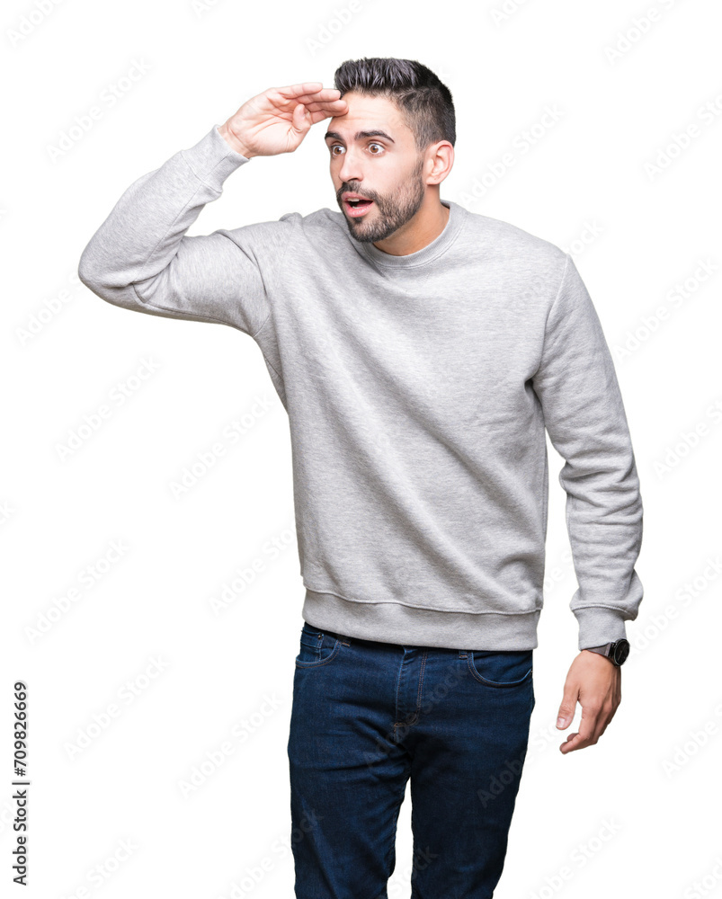 Young handsome man wearing sweatshirt over isolated background very happy and smiling looking far away with hand over head. Searching concept. Young handsome man wearing sweatshirt over isolated background very happy and smiling looking far away with hand over head. Searching concept.
