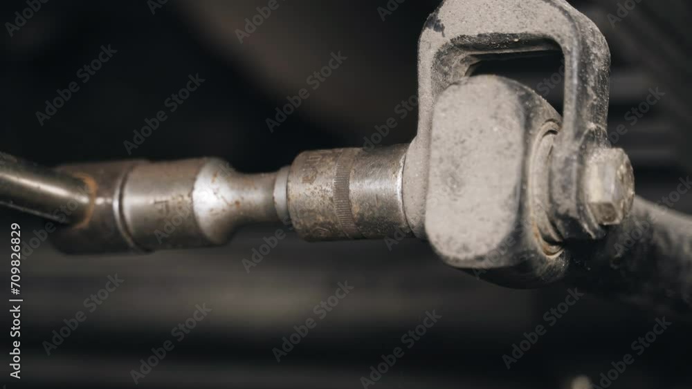 A mechanic tightens bolts with a wrench on the units and parts of a truck in a repair shop. Close-up. A mechanic tightens bolts with a wrench on the units and parts of a truck in a repair shop. Close-up.