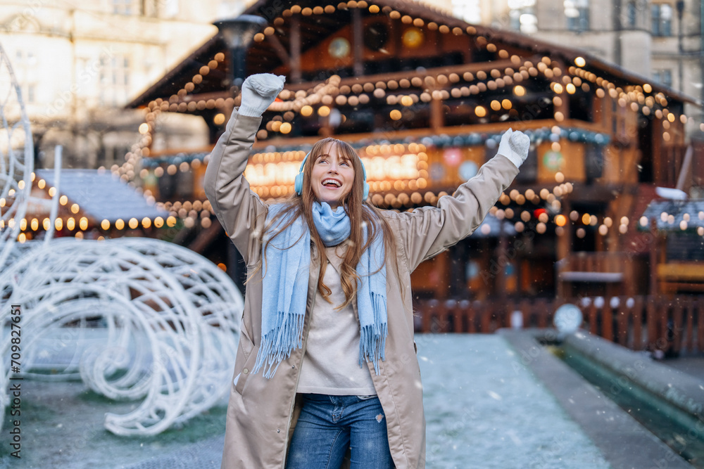 happy young woman having a fun time, using phones, listening to music, and dancing outdoor in city. People, communication,  shopping and lifestyle concept