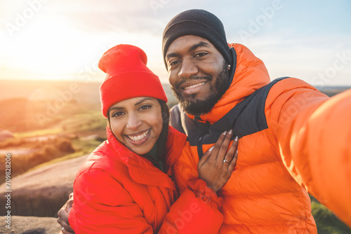 happy couple in love walking along countryside at the sunset. Love, hiking and active lifestyle concept