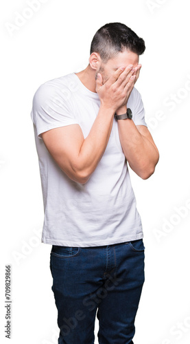 Young man wearing casual white t-shirt over isolated background with sad expression covering face with hands while crying. Depression concept.