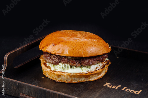 Tasty and big burger on a dark wooden background