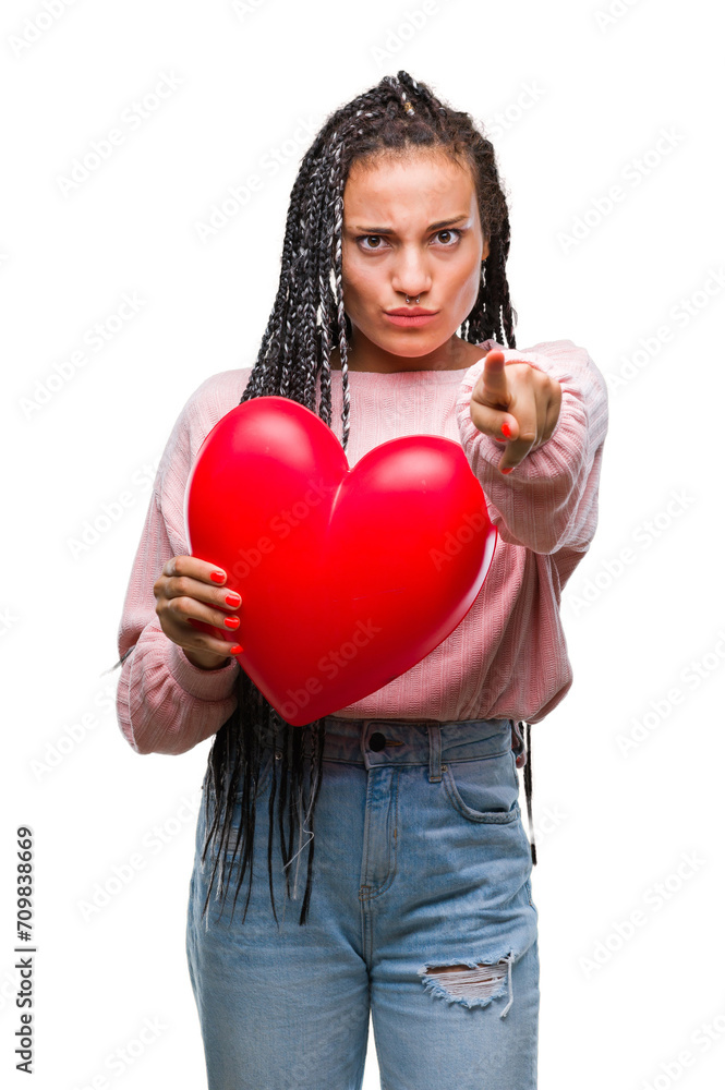 Young braided hair african american girl holding read heart over isolated background pointing with finger to the camera and to you, hand sign, positive and confident gesture from the front Young braided hair african american girl holding read heart over isolated background pointing with finger to the camera and to you, hand sign, positive and confident gesture from the front